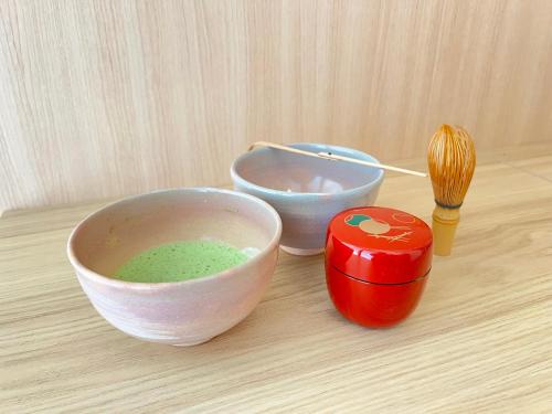 a table with two bowls of green liquid next to apotion at FUMAI sauna &INN-遠赤外線サウナ-松江の歴史と文化と共に過ごすsmart hotel in Matsue