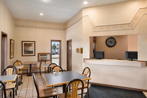 a dining room with tables and chairs and a tv at Super 8 by Wyndham Carbondale in Carbondale