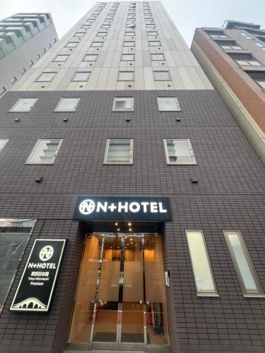 un edificio alto con un cartel de hotel en N+HOTEL東京日本橋, en Tokio