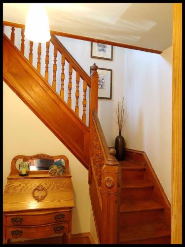 a hallway with a staircase with a wooden stair case at Beautiful Victorian Home On Ocean Side, in Waretown