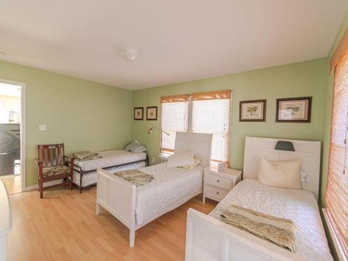 2 camas en una habitación con paredes verdes en Oceanside Vacation Rental On Lbi, en Brant Beach