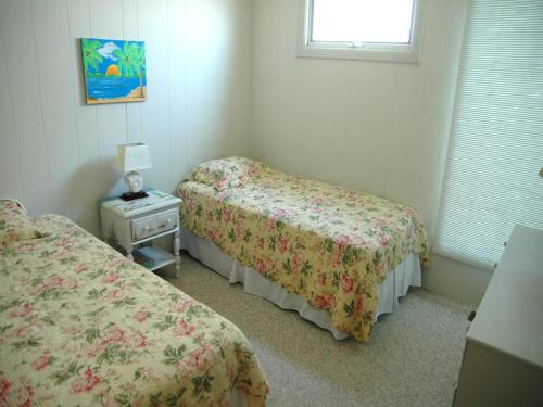 a bedroom with two beds and a table with a lamp at Nice Home In Brant Beach With 4 Bedrooms And Internet in Brant Beach