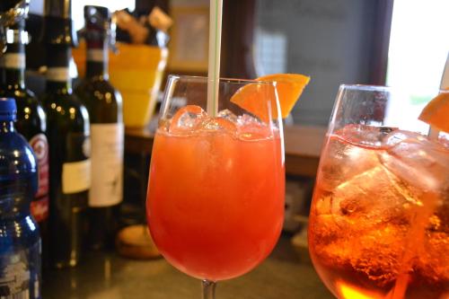 two drinks in glasses sitting on a table with bottles at Locanda La Sosta in Cavaion Veronese