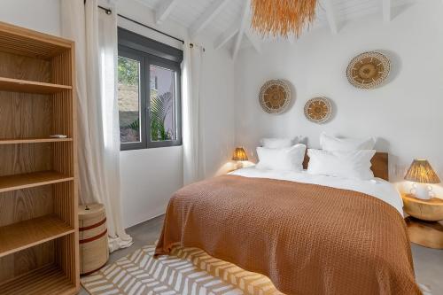 a bedroom with a bed with white walls and a window at 3-bedrooms Villa 5min from Orient Bay in Cul de Sac