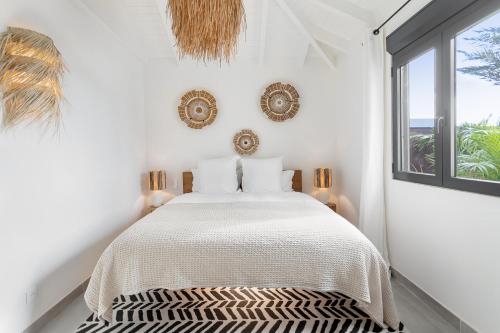 a white bedroom with a bed and a window at 3-bedrooms Villa 5min from Orient Bay in Cul de Sac
