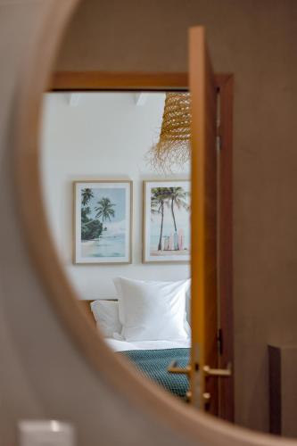 a mirror reflecting a bedroom with a bed and framed pictures at 3-bedrooms Villa 5min from Orient Bay in Cul de Sac