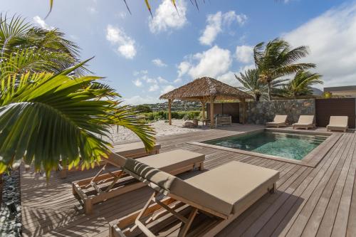 a deck with chairs and a pool and a gazebo at 3-bedrooms Villa 5min from Orient Bay in Cul de Sac