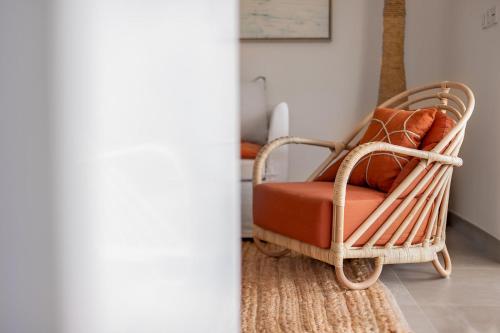 a rattan chair with a red cushion sitting on a rug at 3-bedrooms Villa 5min from Orient Bay in Cul de Sac