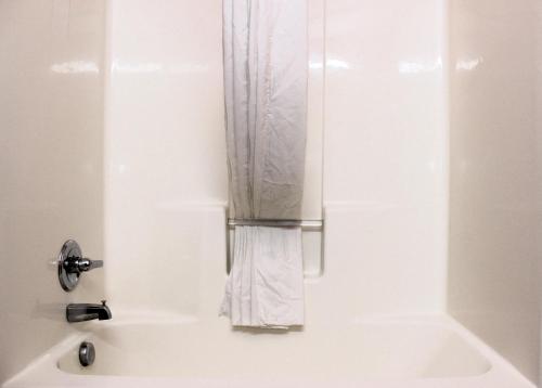 a bath tub with a clear shower curtain at Scottish Inns Killeen near Fort Cavazos in Killeen