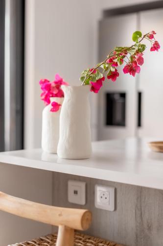two white vases with pink flowers on a counter at 3-bedrooms Villa 5min from Orient Bay in Cul de Sac