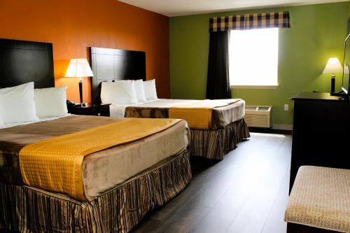 ein Hotelzimmer mit 2 Betten und einem Fenster in der Unterkunft Scottish Inns Killeen near Fort Cavazos in Killeen