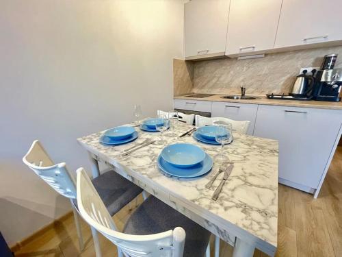 una cocina con una mesa con platos azules. en Panoramic Sea View Apartment - Perfect for Couples, en Varna