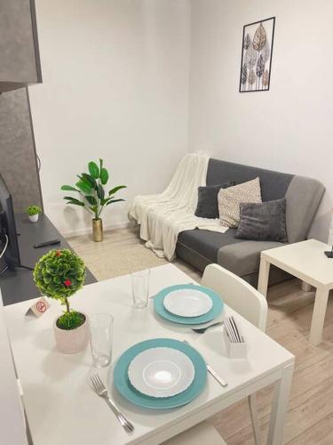 ein Wohnzimmer mit einem weißen Tisch und einem Sofa in der Unterkunft Sunlit Shelter * Ideal Location! Free Parking in Oradea