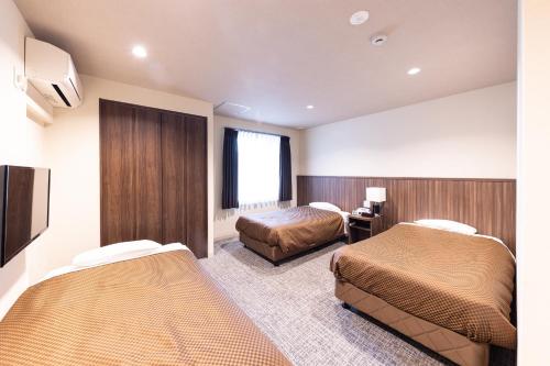 una camera d'albergo con due letti e una finestra di Reco Hotel Mikuni a Toyonaka