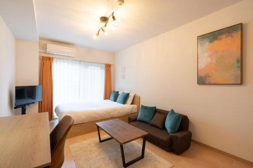 a room with a bed and a couch and a table at KISETSU Omori I in Tokyo