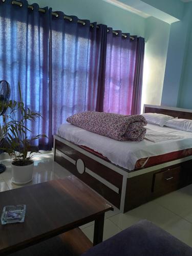 a bedroom with a bed with purple curtains and a table at Bansbari Hotel & Resort in Bhaktapur