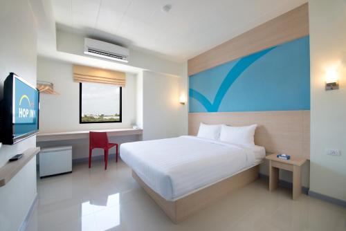 Habitación de hotel con cama y TV en Hop Inn Kanchanaburi Building B en Kanchanaburi