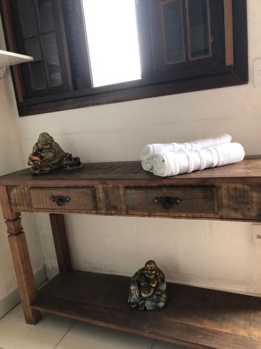 a wooden table with a mirror and towels on it at Pousada Chácara da Índia in Itatiaia