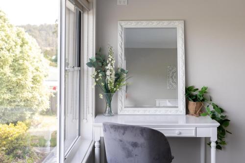 a mirror sitting on a desk next to a window at Legana Lodge - A home away from home - Catering for up to 12 guests in Legana