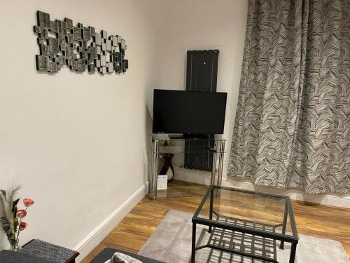 ein Wohnzimmer mit einem Flachbild-TV und einem Stuhl in der Unterkunft Holloway one bedroom apartment in London