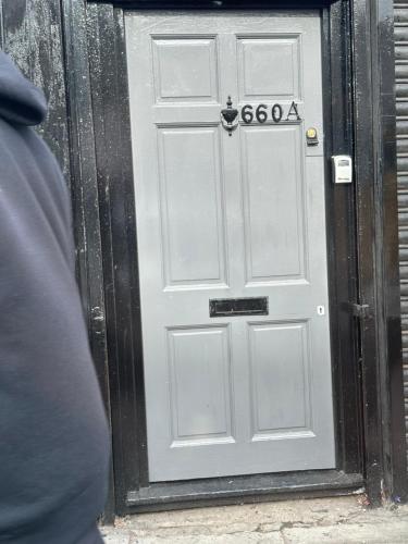 Una puerta gris con una señal. en Holloway one bedroom apartment en Londres