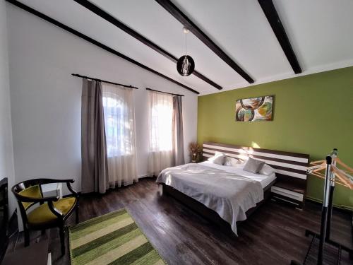 a bedroom with a bed and a green wall at Magic Apartments Hunedoara in Hunedoara