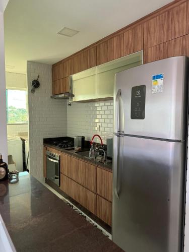 una cucina con frigorifero in acciaio inossidabile e mobili in legno di LINDO AP no Condomínio Topázio a Rio Branco