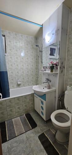 een badkamer met een toilet, een wastafel en een bad bij Casa Suzana 2 camere in Piatra Neamţ