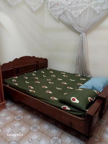 een slaapkamer met een bed met een groen dekbed bij Nhà Anh - Sửu in Dien Bien Phu