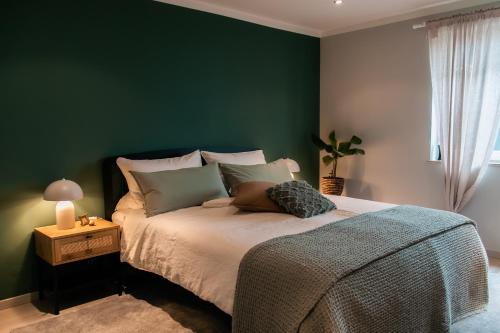 a bedroom with a bed with a green wall at Idyllische Ferienwohnung im Kraichgau in Sinsheim