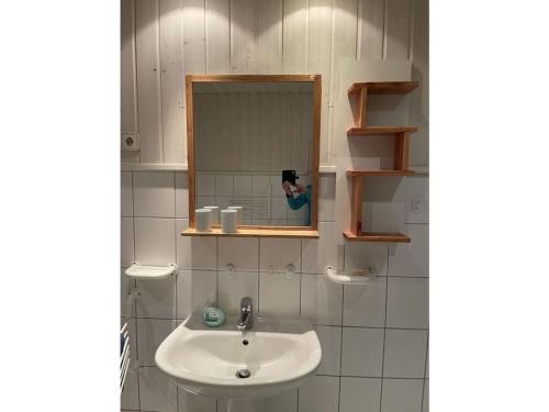 une personne prenant une photo d'un lavabo dans la salle de bains dans l'établissement Hollstein house by the lake, à Stolpe