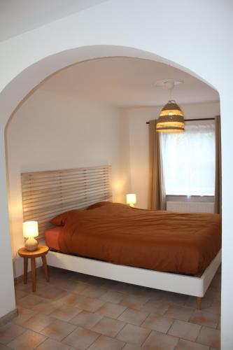 a bedroom with a bed and two lamps and a window at La Maisonnette - 2 chambres, parking, jardinet & calme in Tournai
