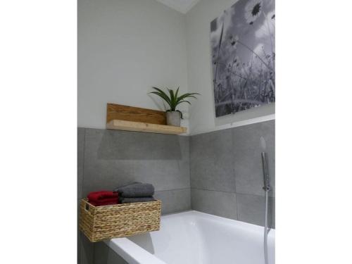 a bathroom with a bath tub with a plant in it at Bodenschneid Suites Wallbergblick in Rottach-Egern