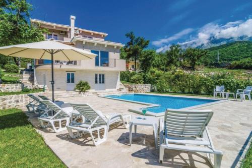a group of chairs and an umbrella next to a swimming pool at Pool Villa Panorama Mojdež - Happy Rentals in Igalo