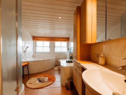 La salle de bains est pourvue d'une baignoire, d'un lavabo et d'une baignoire. dans l'établissement Chic holiday apartment, à Oy-Mittelberg