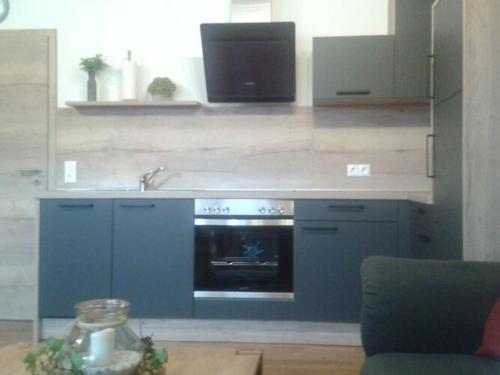 een blauwe keuken met een wastafel en een oven bij Holiday apartment Tulpe Schuniglhof 
