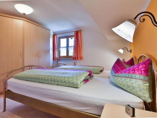 um quarto com 2 camas e almofadas coloridas em Haus Brandl Modern retreat em Ramsau