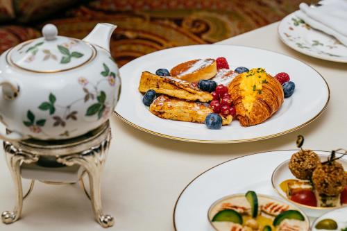 a table with two plates of breakfast foods and a teapot at The Ritz-Carlton, Bahrain in Manama