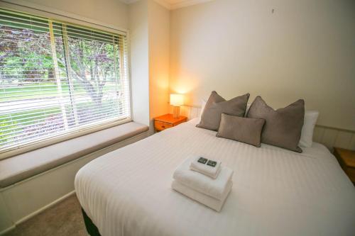 a bedroom with a large white bed with a window at Silver Birches Holiday Village - Unit 8 in Bright