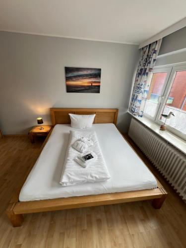 a bedroom with a white bed in a room at Hotel Tum Stüürmann in Büsum