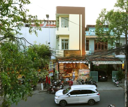 um carro branco estacionado ao lado de uma rua da cidade em Hoian Old Town Hostel em Hoi An