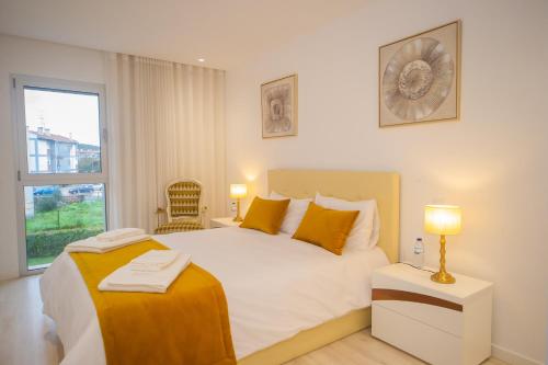 Un dormitorio con una gran cama blanca y una ventana en Batalha - Ferreiras Apartment en Batalha