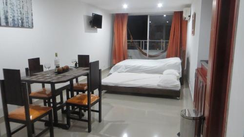 1 dormitorio con 1 cama, mesa y sillas en Aparta-estudio con hermosa vista, en Cartagena de Indias
