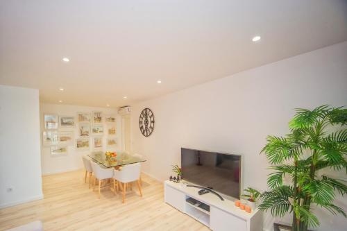 a living room with a dining table and a tv at Batalha - Ferreiras Apartment in Batalha