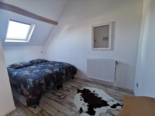 Schlafzimmer mit einem Bett und einem Fenster in der Unterkunft Le p'tit coin dans les vignes in Restigné
