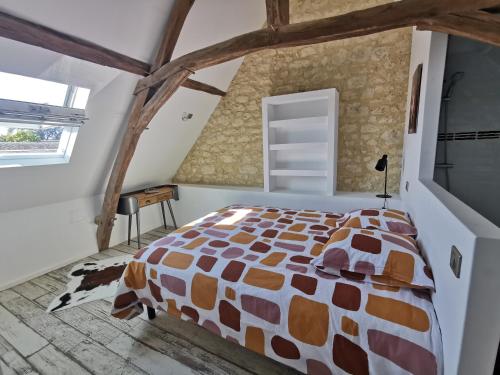 Schlafzimmer mit einem Bett und einem Fenster in der Unterkunft Le p'tit coin dans les vignes in Restigné