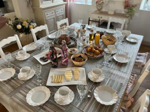 a dining table with plates and glasses and food on it at Château Ségot in Neuilly-le-Réal
