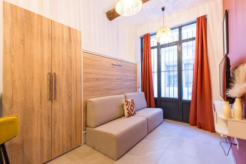 un salon avec une chaise et une fenêtre dans l'établissement Charmant Studio N•1 Neuf - Centre ville, à Montpellier