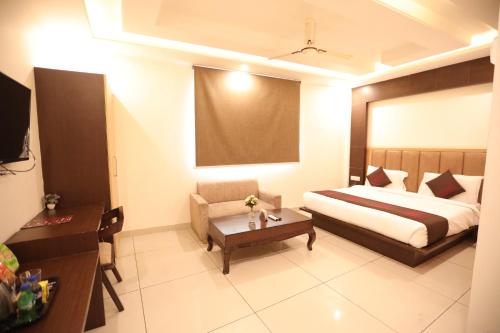 um quarto com uma cama, um sofá e uma mesa em Corporate Suites Noida 116 em Noida