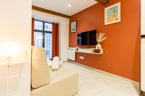 een woonkamer met een oranje muur bij Charmant Studio Neuf N•2 - Centre ville in Montpellier